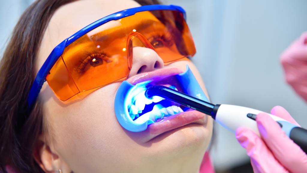 A beautiful girl undergoing a teeth whitening treatment process in a dental clinic