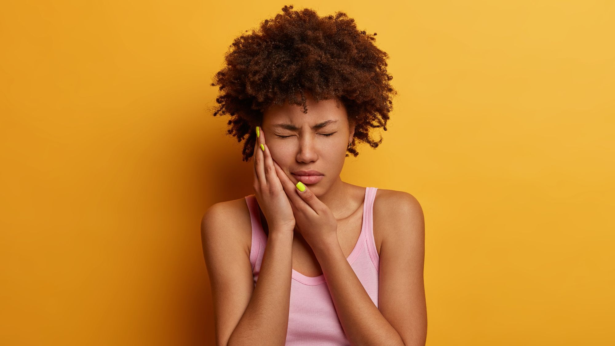 A girl holding her mouth in pain due to sensitive teeth