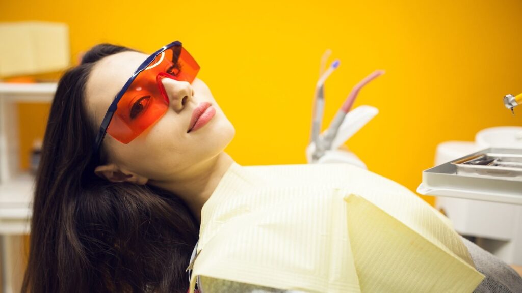 Smiling woman receiving teeth whitening treatment for a brighter smile