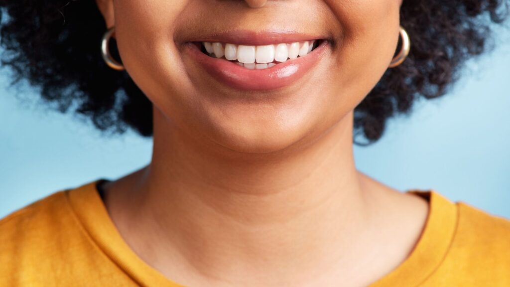 A smiling woman demonstrating the correct toothbrush for good oral health care
