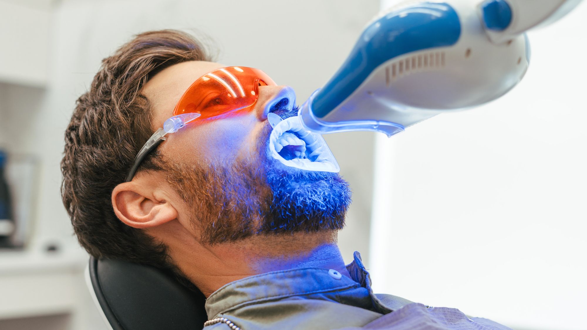 A man is undergoing a teeth whitening process