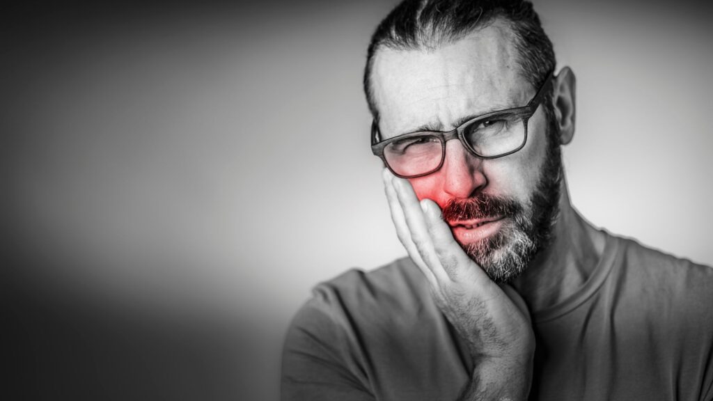 A man suffering from a severe toothache