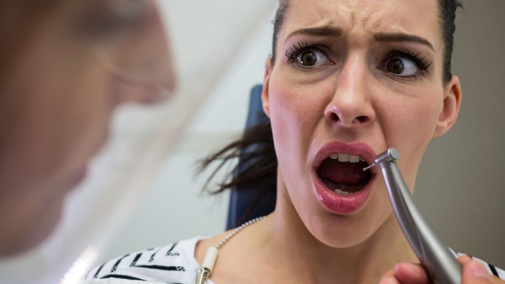 A woman expressing concern and fear due to an upcoming dental treatment with an emergency dentist